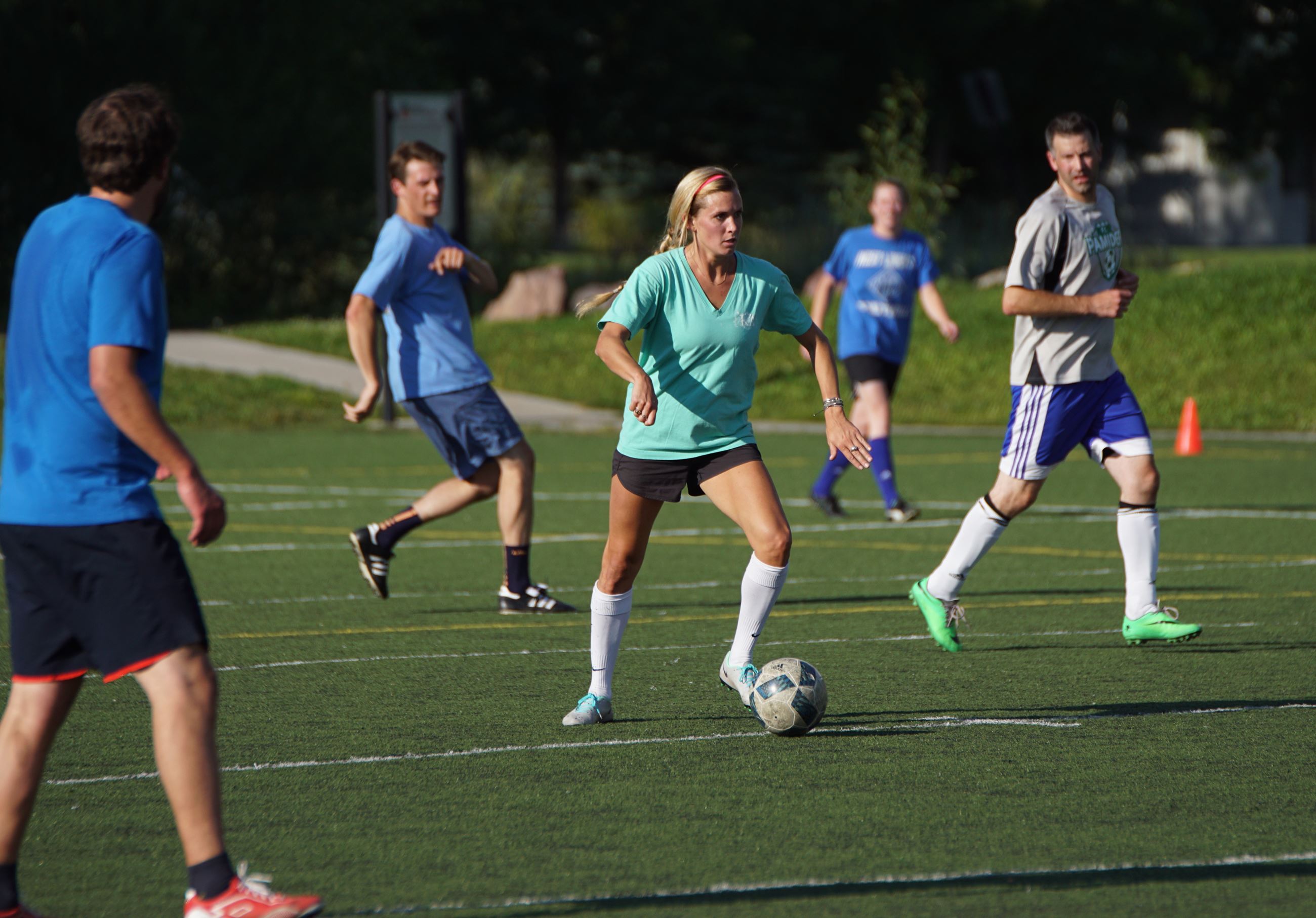 Co-ed Group of people playing soccer in county rec league